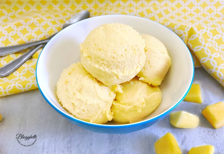 2 ingredient mango sherbet in blue and white bowl with yellow cloth in background