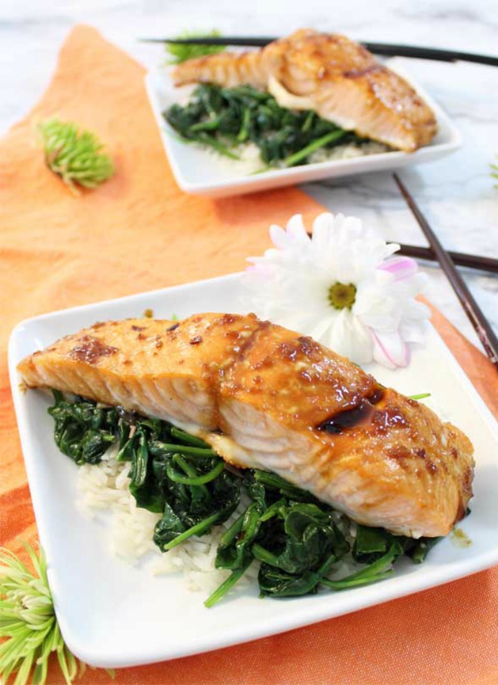 Baked Salmon with greens and white rice for two both served on white plates