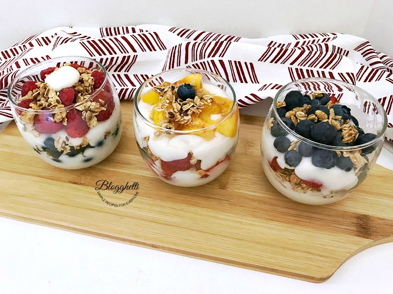 Fresh Fruit and Yogurt in glass containers on a wooden board