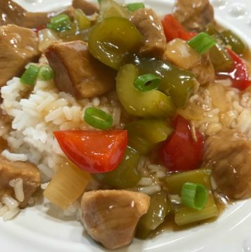 Sweet and Sour Pork served over white rice on a white plate
