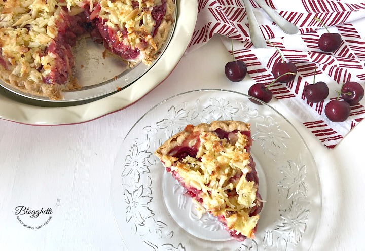 Slice of Macaroon Cherry Pie with the pie plate in the background