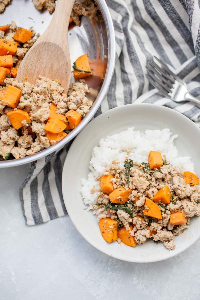 ground turkey with sweet potatoes on white plate with skillet in background