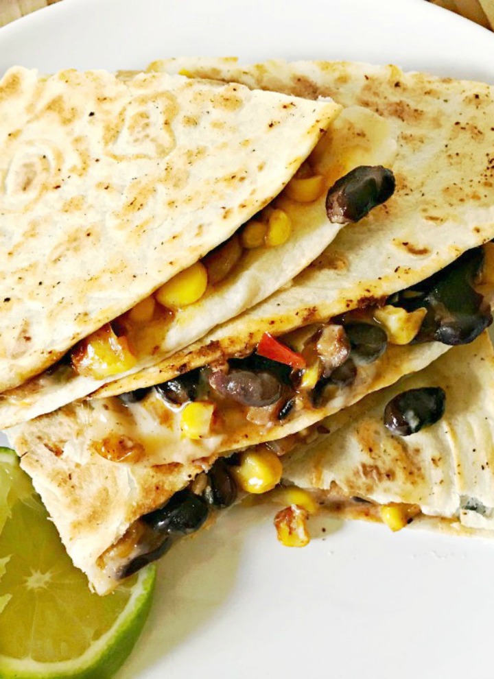 Black Bean and Roasted Corn Quesadillas served on a white plate with a lime slice