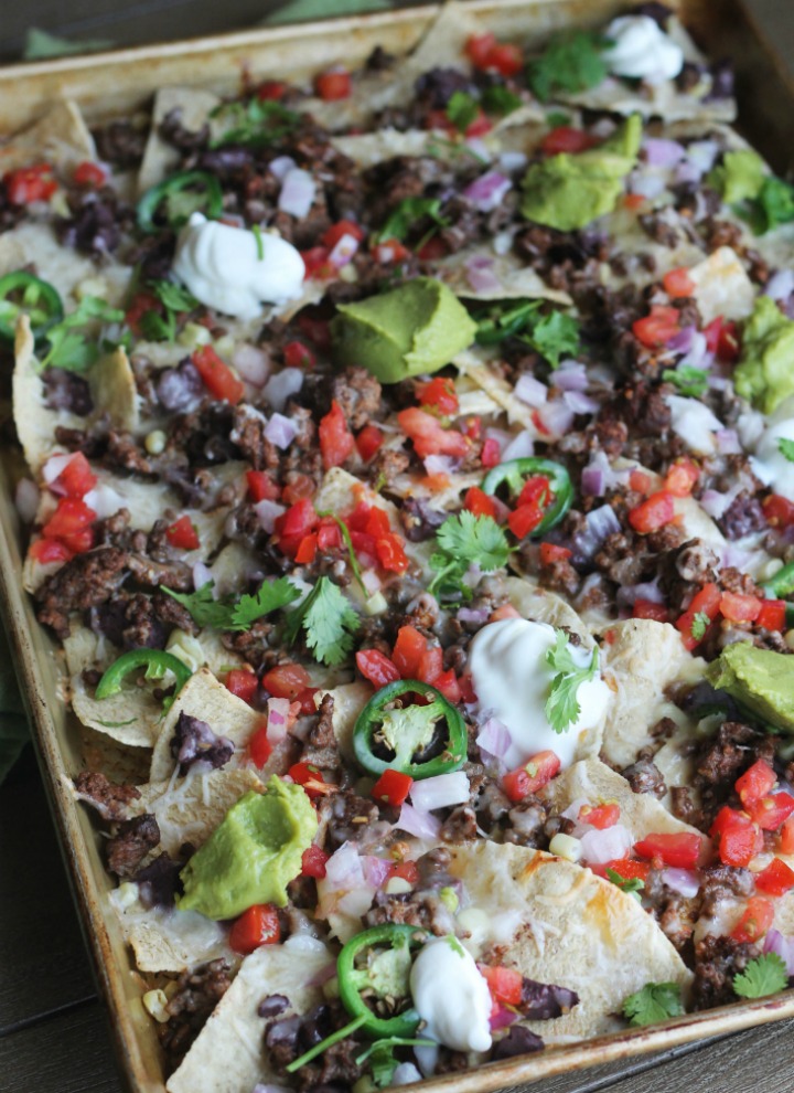 Sheet-Pan-Beef-Nachos-loaded-with-cheese-tomatoes-jalapenos-beans-corn-and-queso