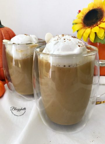 two glasses of pumpkin spice hot chocolate with whipped cream on top