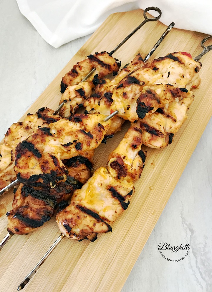 Grilled bang bang chicken skewers on wooden plank