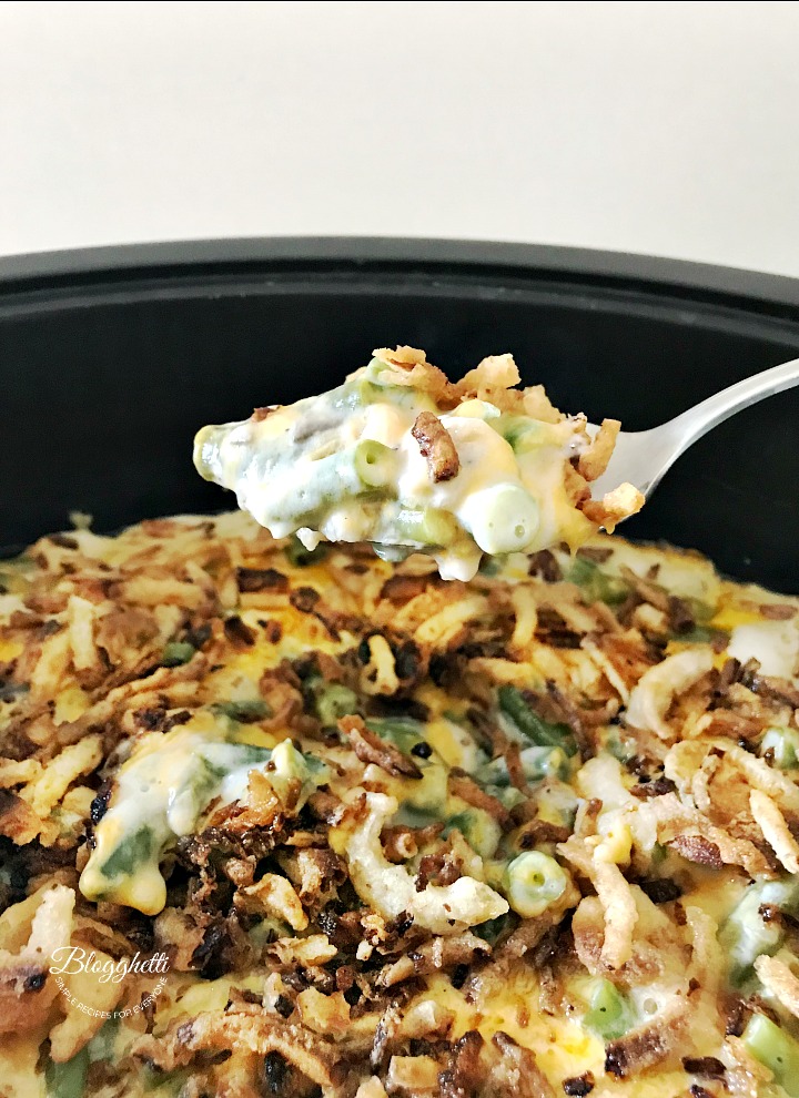 a spoonful of cheesy green bean casserole made in the slow cooker