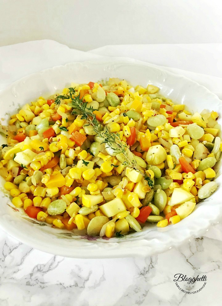 White bowl filled with southern succotash on a marble countertop