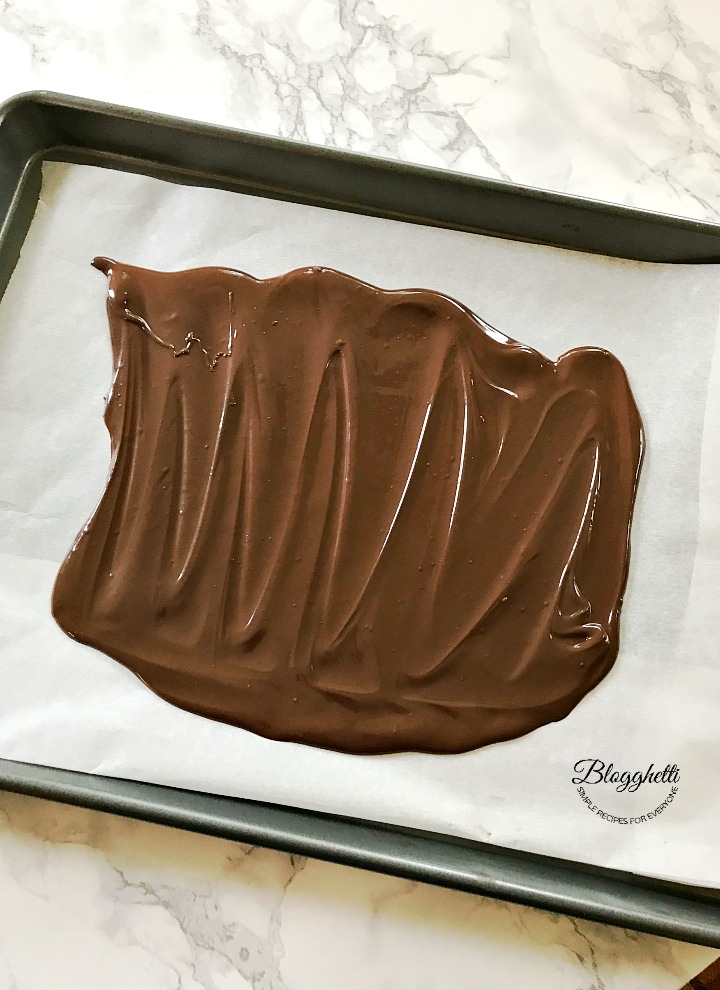 Spreading the melted chocolate on a sheet pan