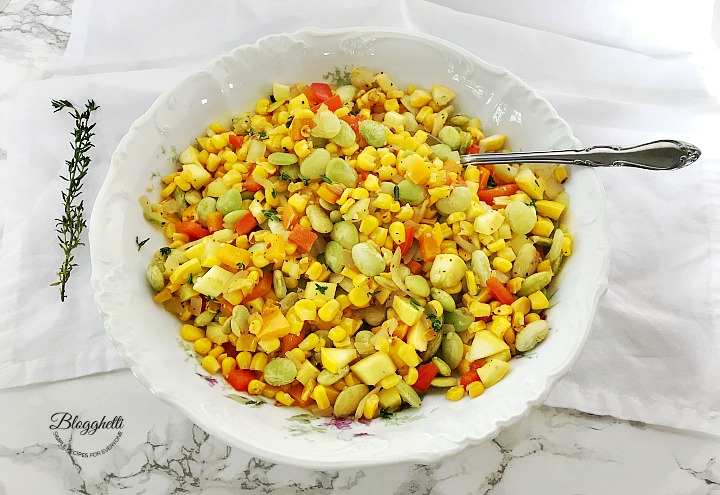 White bowl filled with southern succotash on a marble countertop