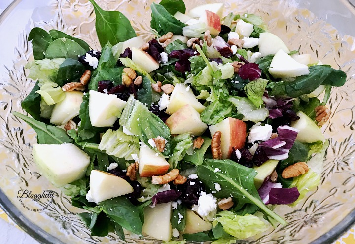 apple cranberry pecan salad with spinach in a crystal bowl