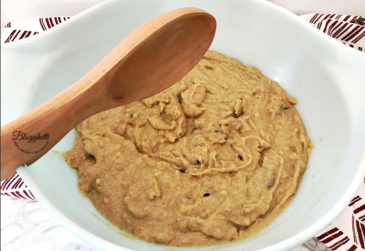 sweet potato bread batter in white bowl with wooden spoon