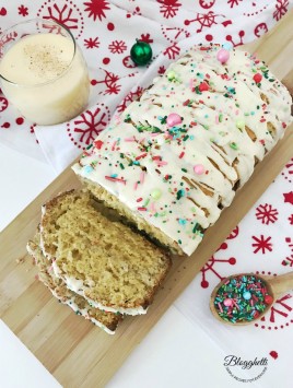 Holiday Eggnog Bread with glass of eggnog and sprinkles