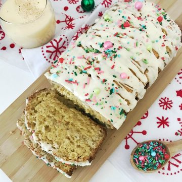 Holiday Eggnog Bread with glass of eggnog and sprinkles
