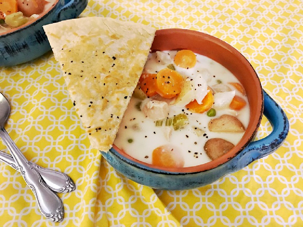 Crock pot  chicken pot pie soup in a bowl with pie crust wedge