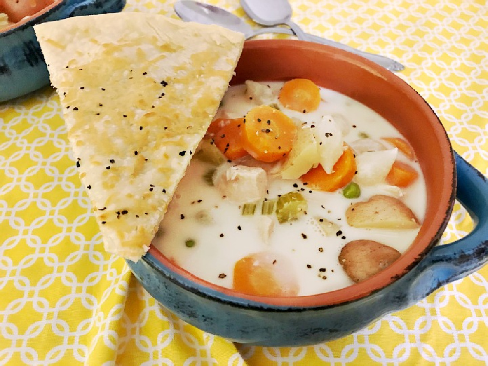 bowl of chicken pot pie soup served with Parmesan cheese pie crust