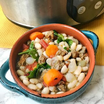 bowl of Tuscan White Bean Soup with Sausage made in the slow cooker