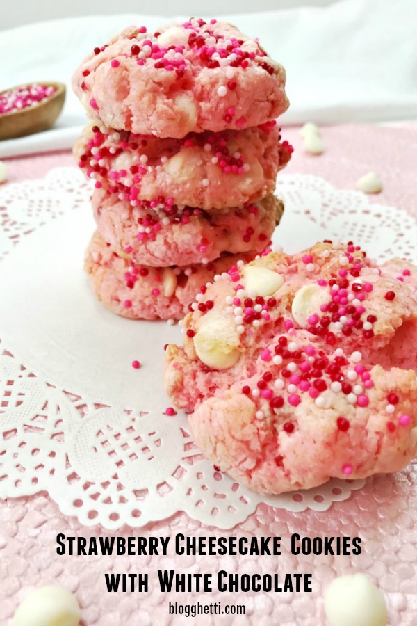 Strawberry Cheesecake Cookies with White Chocolate stacked on a white paper doily 