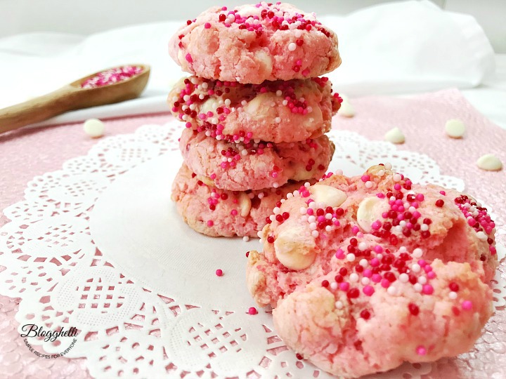 strawberry cheesecake cookies with white chocolate stacked on a white doily