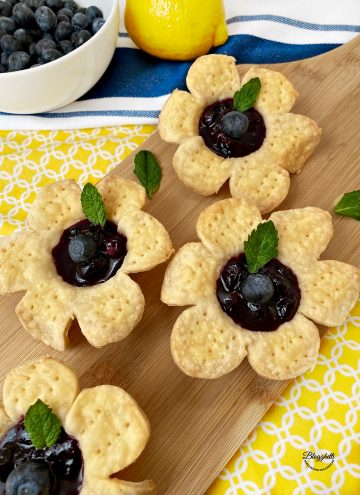 Blueberry flower tarts with mint leaf for garnish
