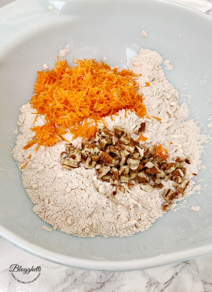 adding ingredients for carrot cake scones in bowl