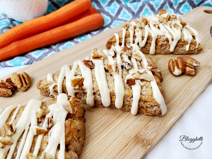 carrot cake scones with maple cream cheese frosting on a wooden board