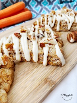 close up of carrot cake scones with fresh carrots in the background