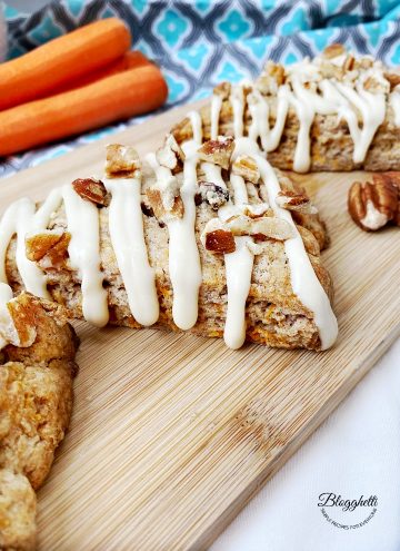 close up of carrot cake scones with fresh carrots in the background