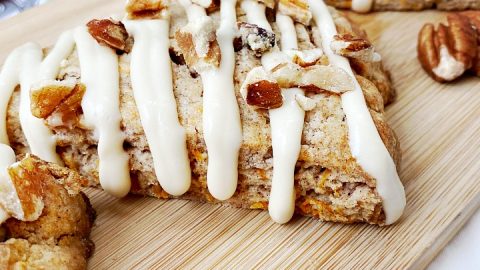 close up of carrot cake scones with fresh carrots in the background