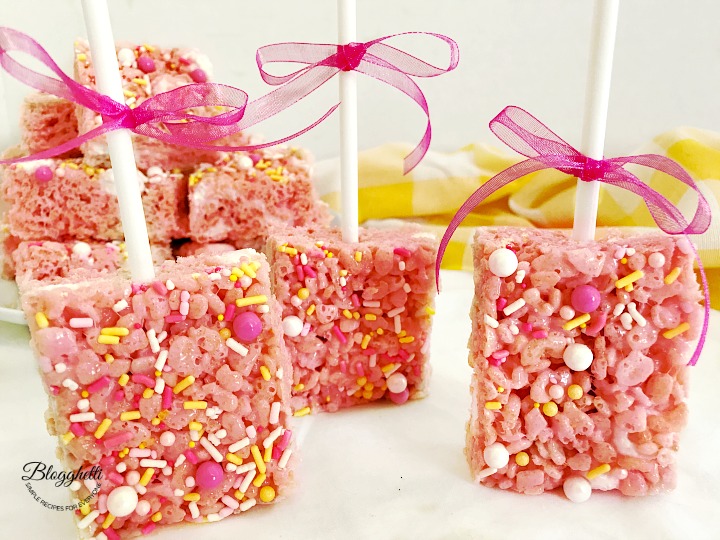 pink lemonade rice krispie treats on lollipop sticks with ribbons
