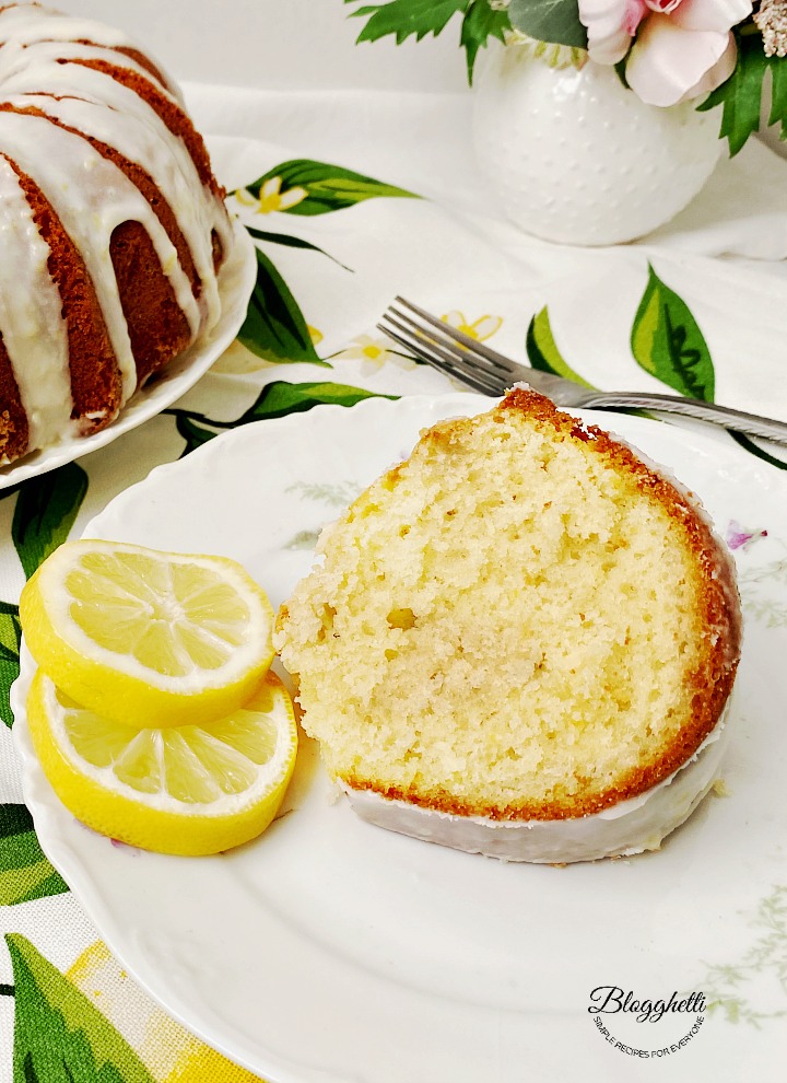slice of lemon bundt cake with lemon glaze on white china plate
