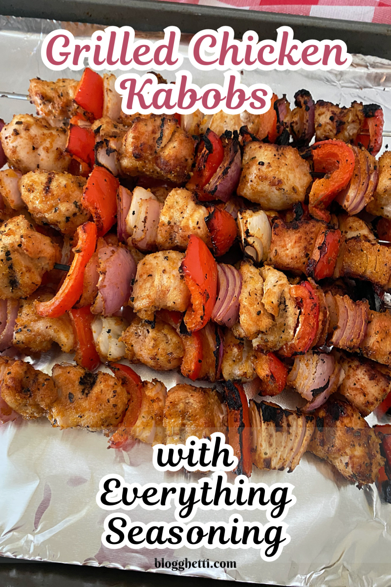 Grilled chicken kabobs with red bell peppers, red onion, and Flavor God Everything Seasoning on a baking sheet.