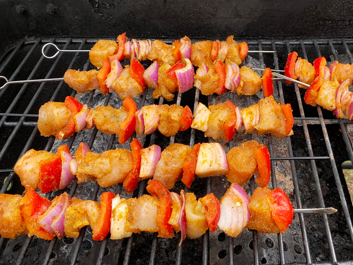 place schicken kewers on grill to cook