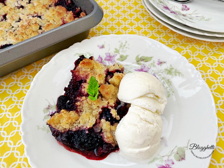slice of blackberry cobbler with vanilla ice cream on a white china plate