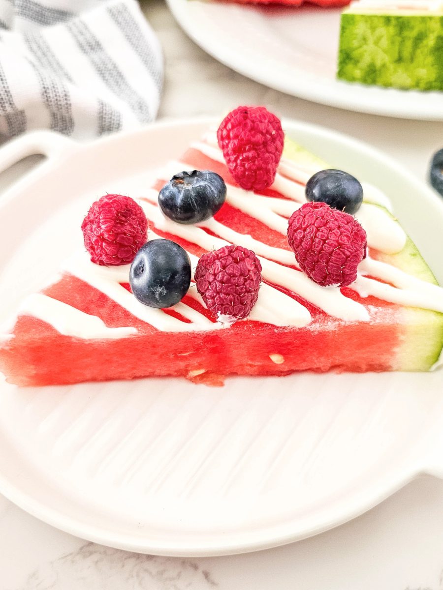 close up of watermelon pizza wedge with berries