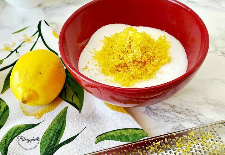 Lemon zest and sugar in red bowl with zester