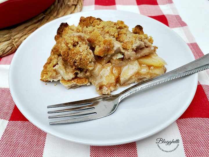 close up of Amish pear crumb pie slice on white plate with fork