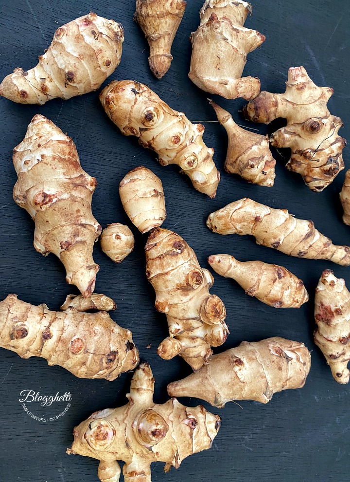 sunchokes spread out on a black background
