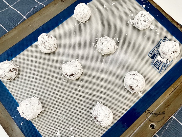 chocolate crinkle cookie dough balls on baking sheet