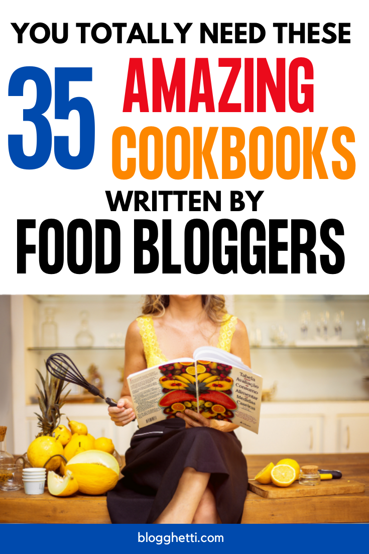 Bold text at the top reads, "You Totally Need These 35 Amazing Cookbooks Written by Food Bloggers," with "35" in large blue font, "Amazing Cookbooks" in vibrant red and orange, and "Food Bloggers" in black. Below, a woman in a yellow top and black skirt sits on a counter holding an open cookbook featuring a vibrant fruit display. Surrounding her are kitchen items, fresh lemons, and a whisk.