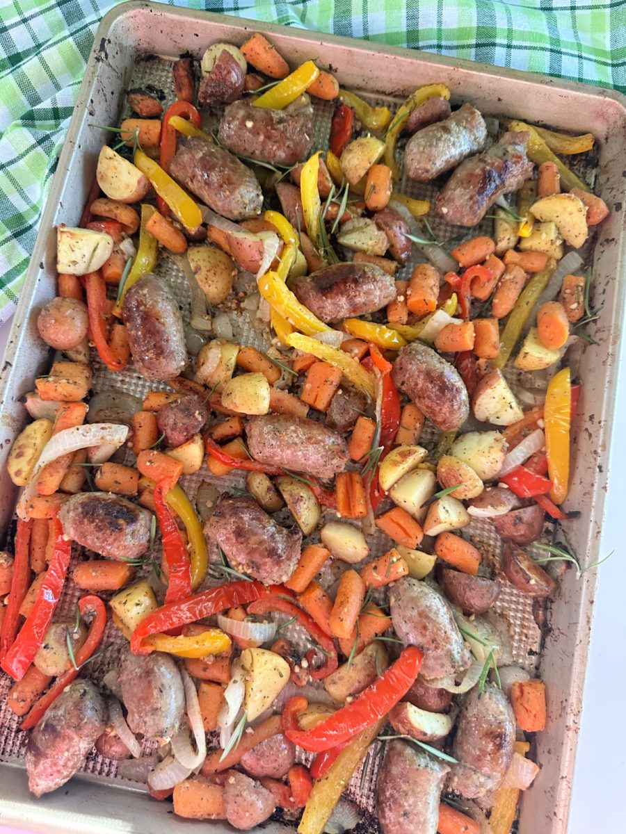 Roasted Italian sausage, carrots, potatoes, and peppers fresh out of the oven on a sheet pan, ready to eat.