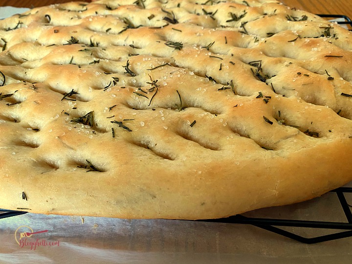 Freshly baked rosemary focaccia bread cooling on wire rack