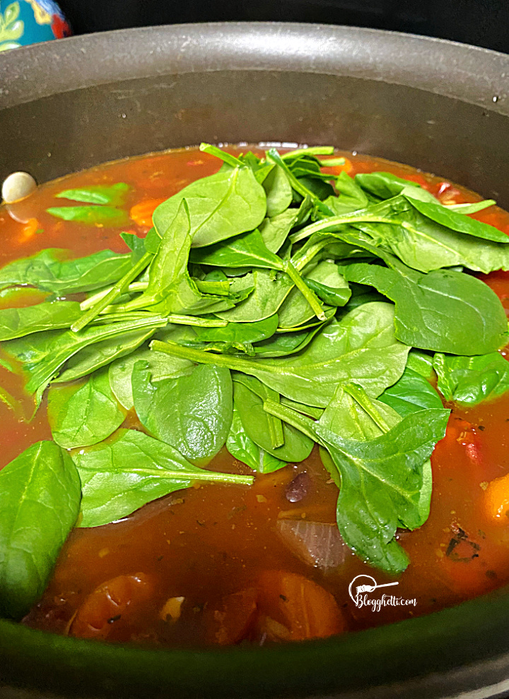 adding spinach to the vegetable soup