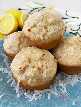lemon coconut muffins on blue plate with fresh lemons in background