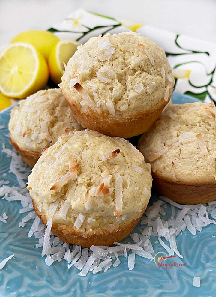 lemon coconut muffins on blue plate with fresh lemons in background