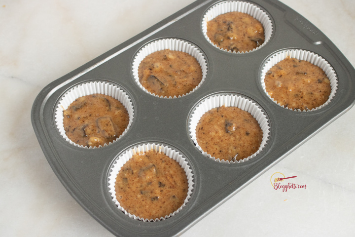 muffins tin filled with banana chocolate chunk batter ready to bake