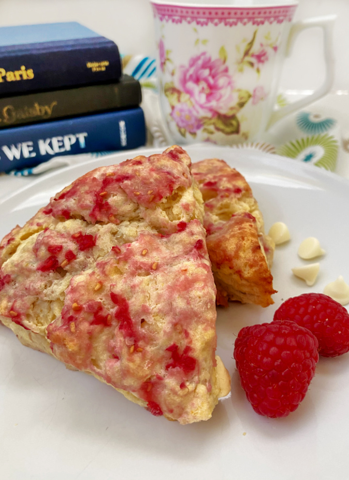 coffee cup with rasp scones with books in the background
