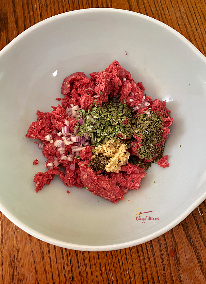 large bowl with ground beef and seasonings for meatballs
