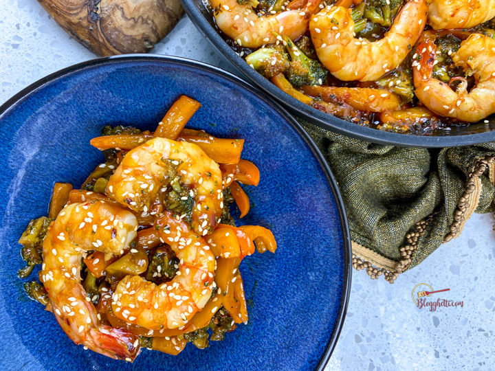 spicy honey garlic shrimp skillet on blue plate