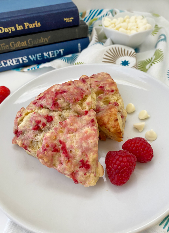white chocolate raspberry scones on plate with books in background